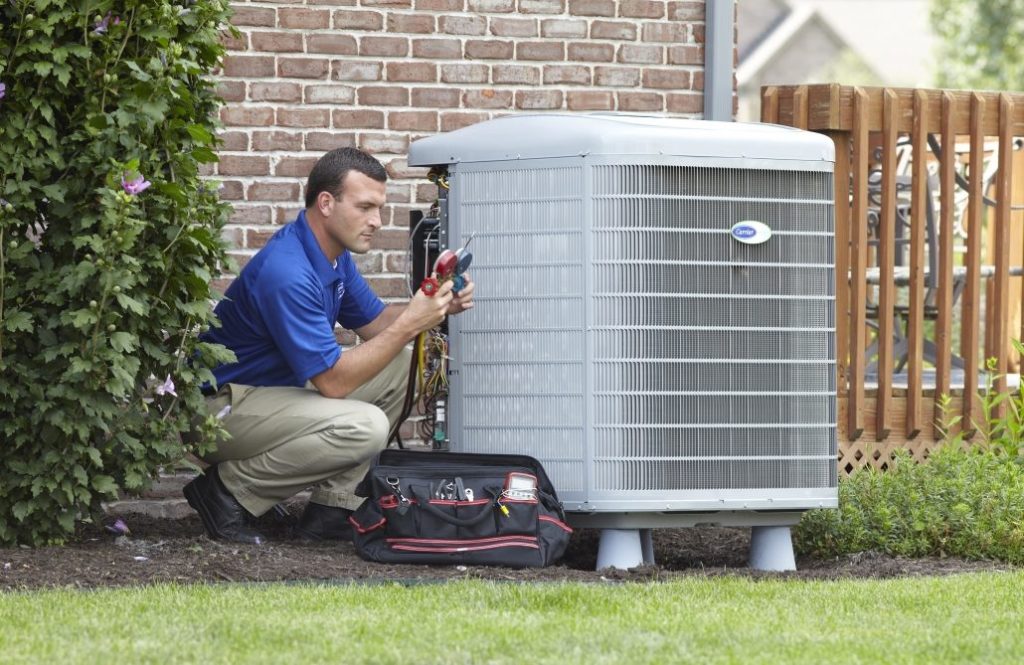 A technician performing maintenance on an air conditioner