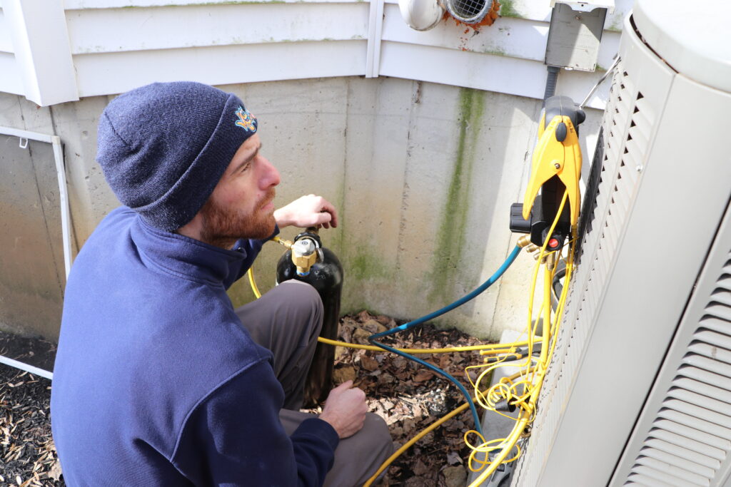 HVAC technician checking a home's AC unit to ensure it is working