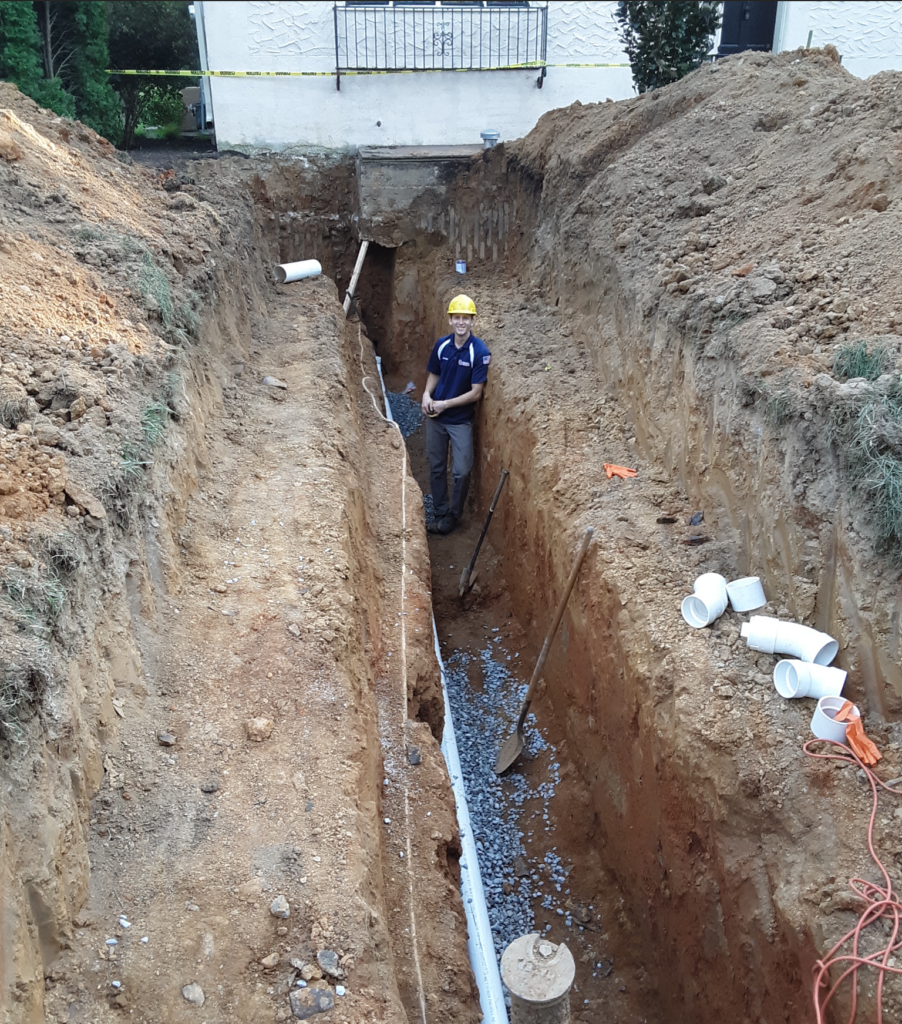 Mattioni team member working on a sewer line in a trench