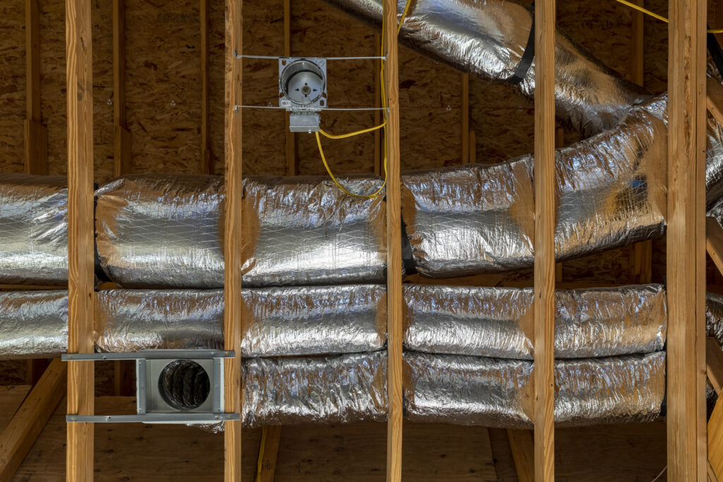 HVAC ductwork in newly built home's ceiling behind construction 