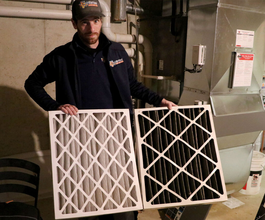 Mattioni HVAC contractor holding up a clean air filter and a dirty air filter