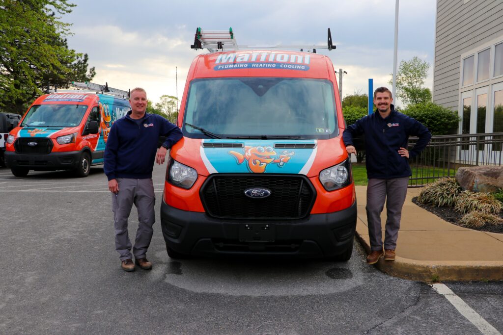 2 Mattioni team members standing by the service truck outside the office