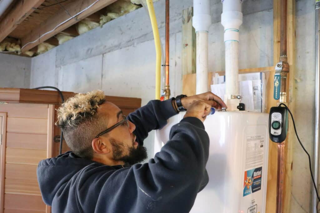 Plumber repairing a tankless water heater in Southeastern PA home
