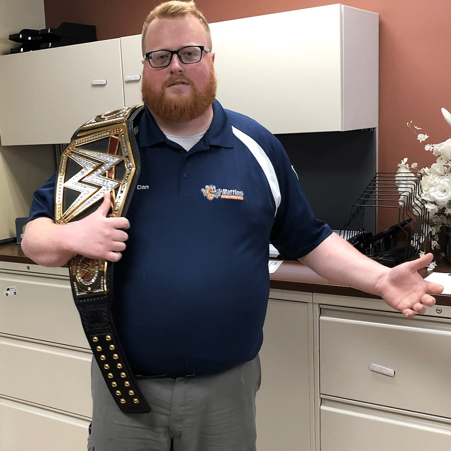 Mattioni employee holding a wrestling belt
