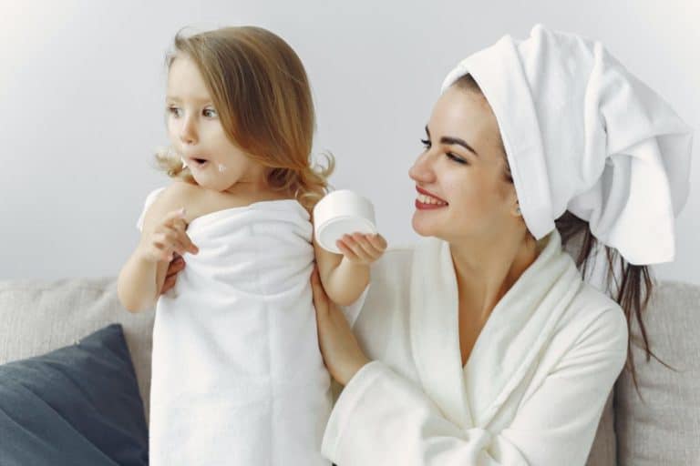 mother in robe and hair towel holding her daughter in towel