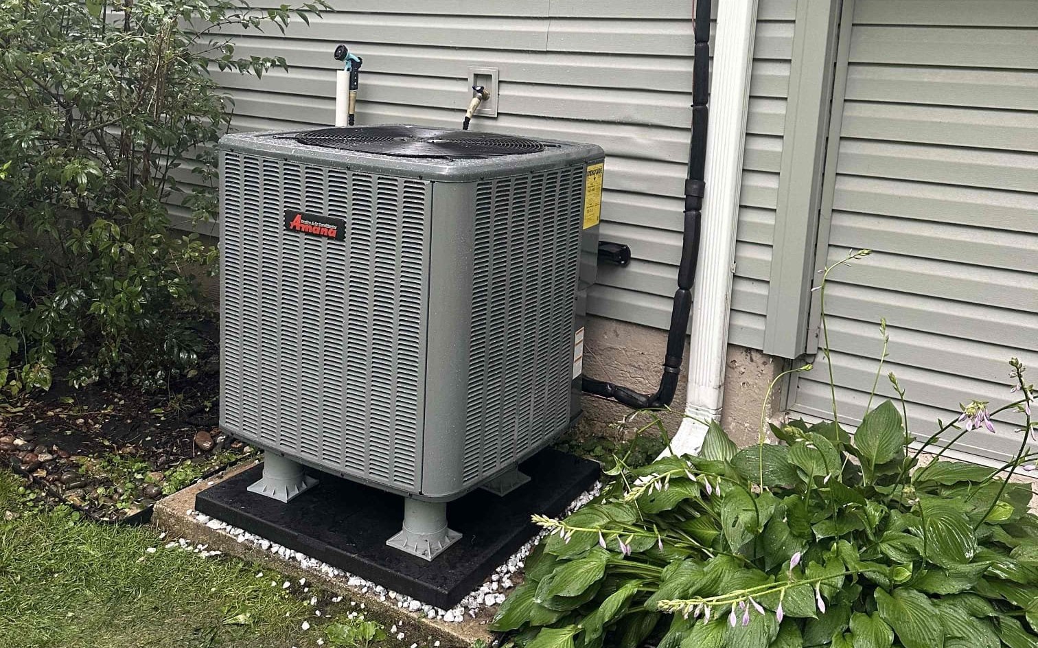 A heat pump outdoor unit installed on a level pad beside a home