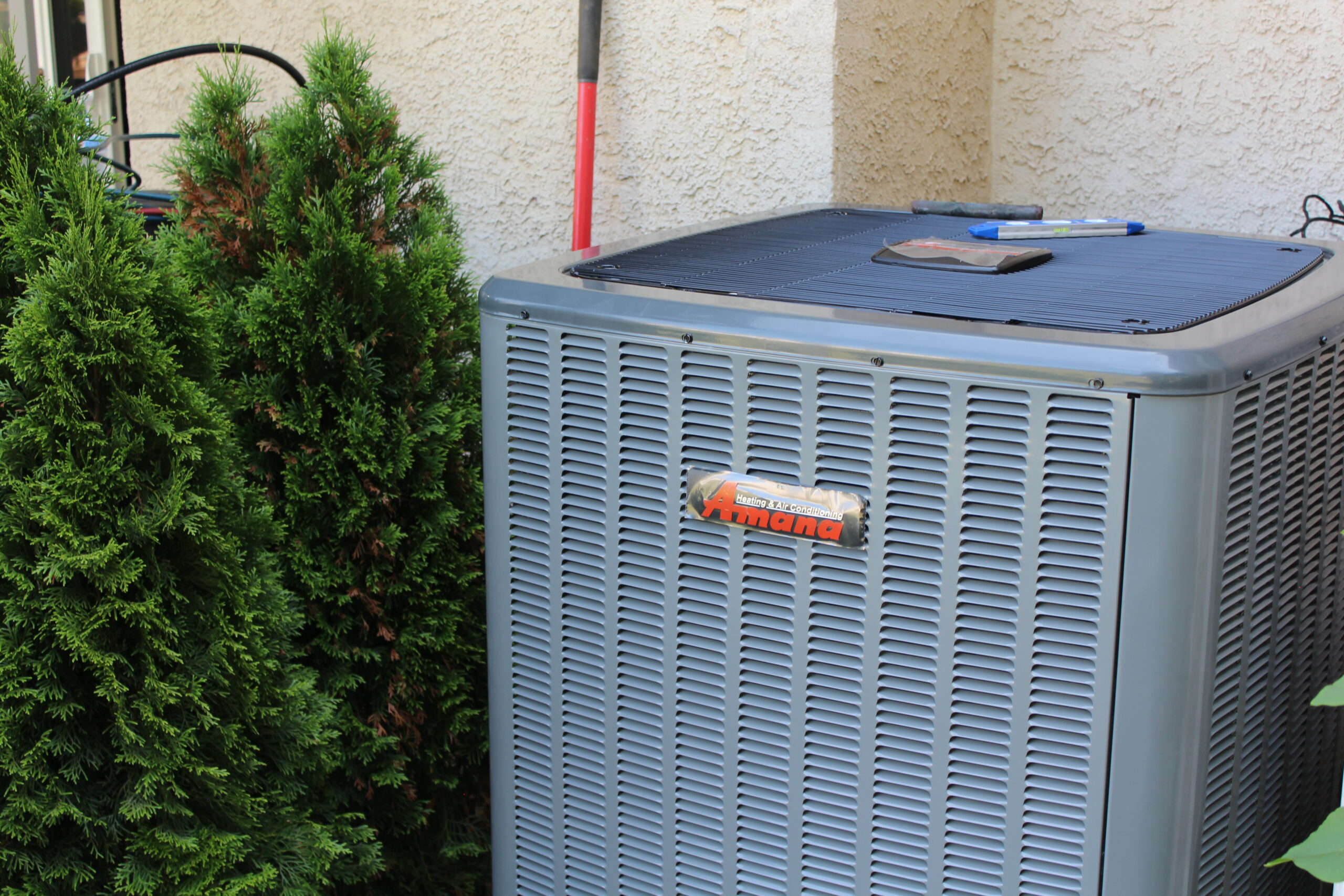 A newly installed Amana air conditioner condenser beside a home